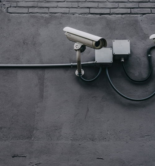 two bullet surveillance cameras attached on wall